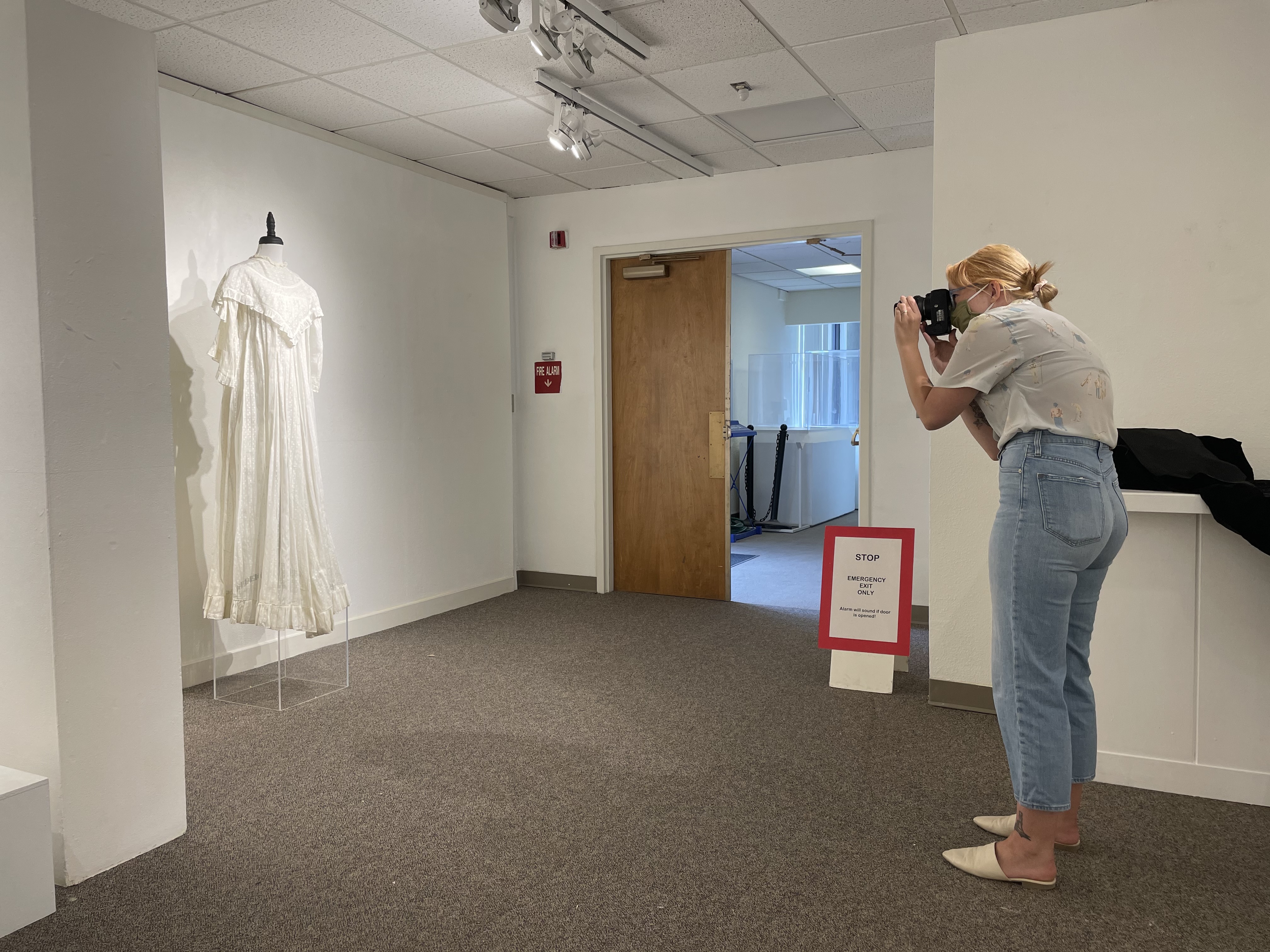 Courtney Uldrich photographing a historical dress from the museum's collection.