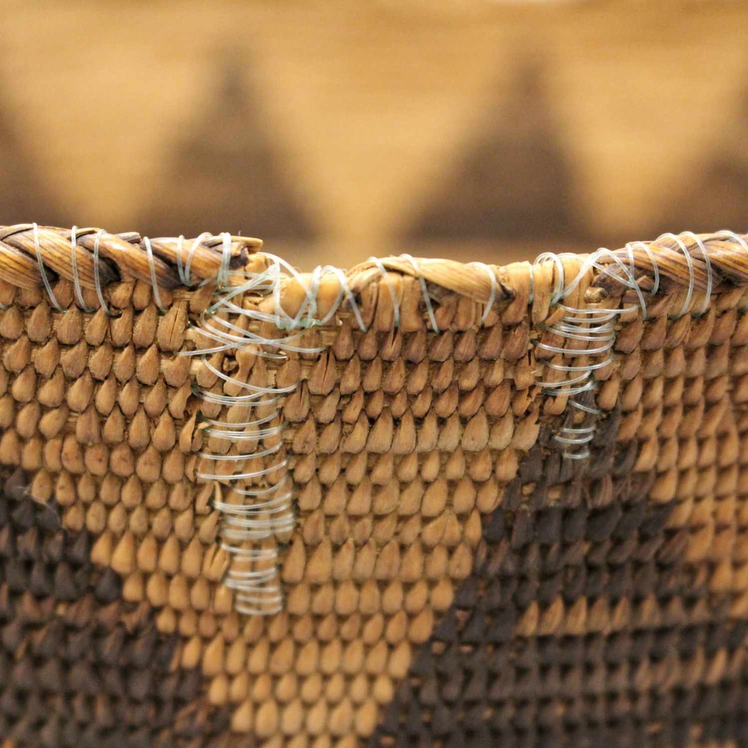 Repaired tan and brown Basket with new stitching at the top.
