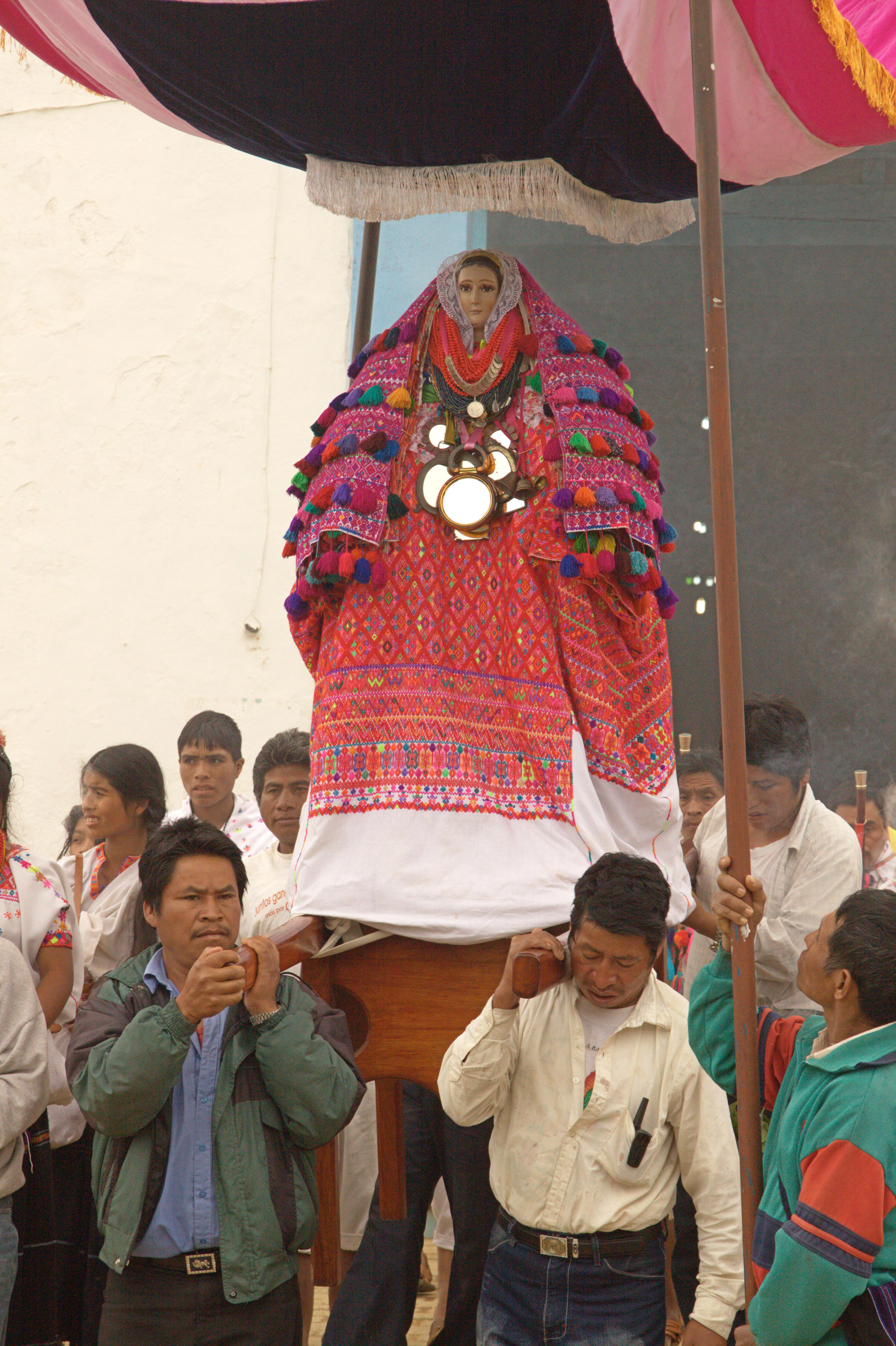 Santa María Magdalena dressed in an elaborate multicolored hand-woven huipil processed through the streets of Magdalenas by four men.
